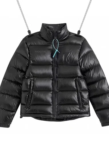 Schwarze Steppjacke mit Stehkragen an einem Bügel, vor weißem Hintergrund fotografiert