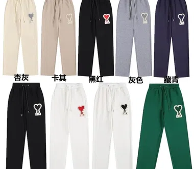 Neun Jogginghosen in Beige, Khaki, Schwarz, Grau, Marine, Weiß und Dunkelgrün mit Herz-Aufnäher und chinesischen Farbnamen darunter