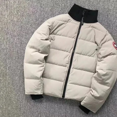 Hellgraue Steppjacke mit Stehkragen, auf hellem Untergrund fotografiert