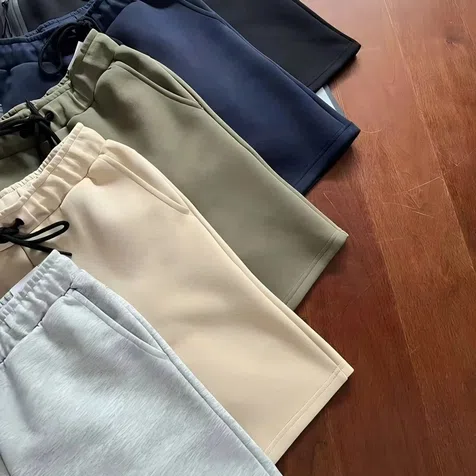 Gefaltete Jogginghosen in Schwarz, Grau und Sand mit Kordelzug, nah fotografiert